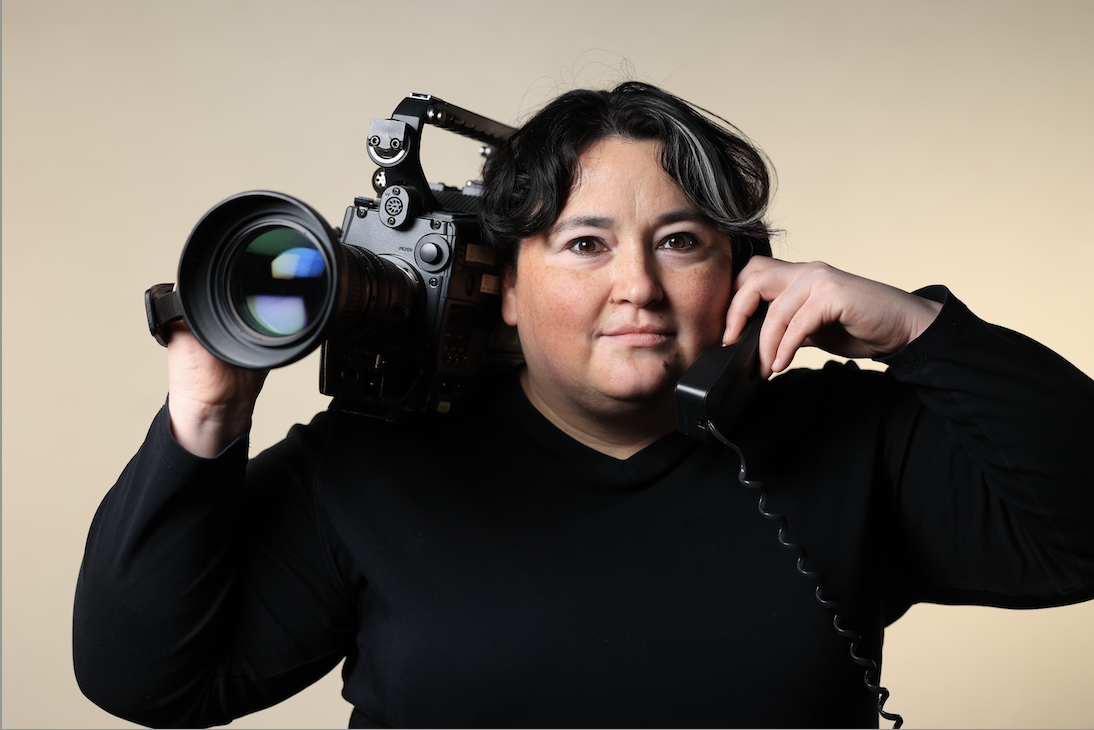 Portrait of Amanda Kindzierski holding a video camera and phone